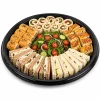 Large black round catering platter filled with triangular sandwiches
